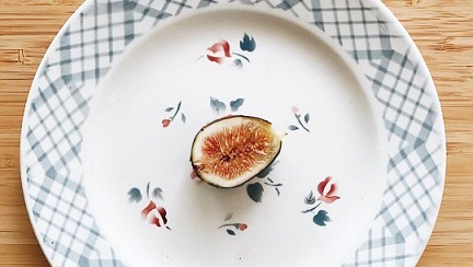 Enlarge in new tab. On a table there is a plate, on it lies a sliced fig 